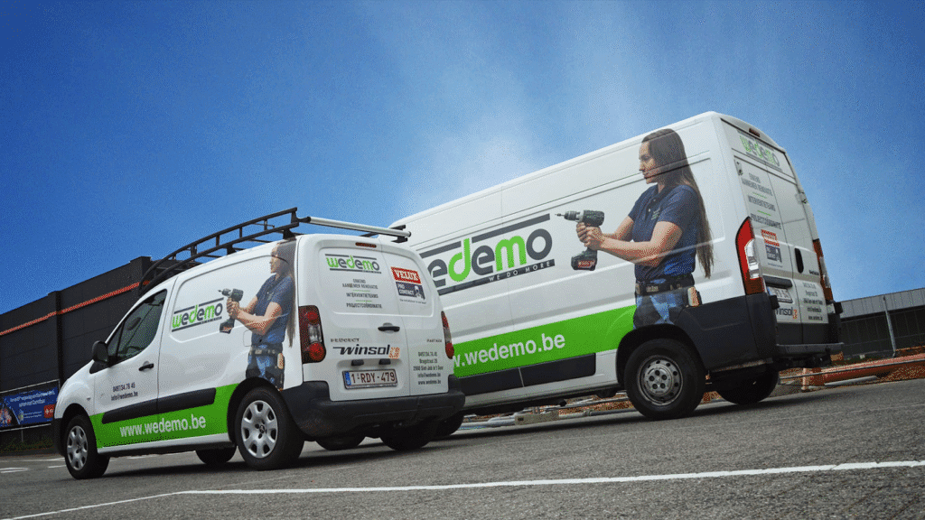 Witte camionettes met bedrijfsreclame 