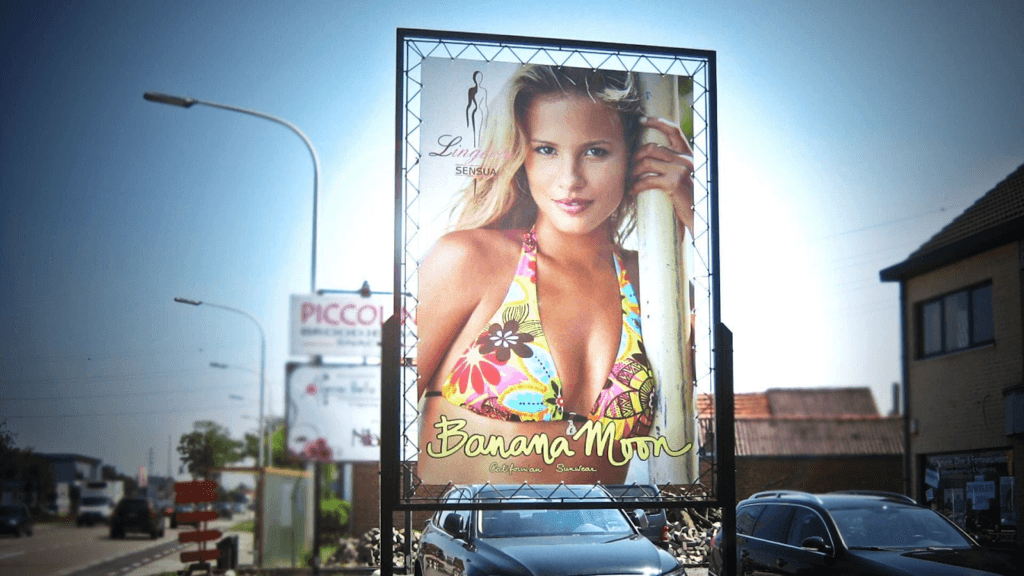 textielframe in het straatbeeld met daarop een afbeelding van blonde vrouw in bikini voor merk Banana Moon 