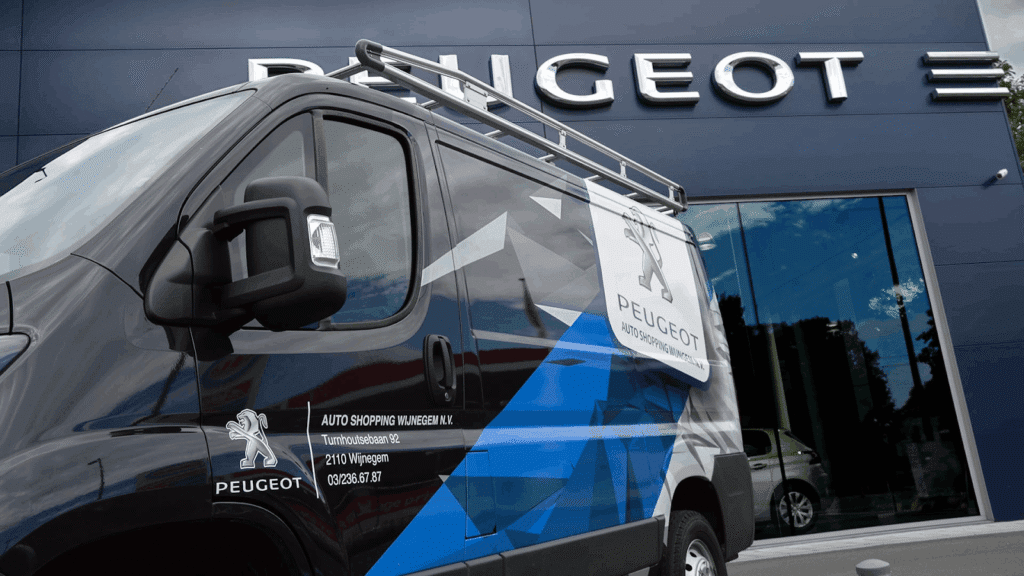 zwarte wagen met reclame voor Peugeot voor Peugeotgarage